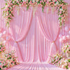 Fondo de tela rosa decorado con guirnaldas florales y cortinas drapeadas, preparado para un evento.
