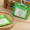 Green hanging bags filled with white moisture absorber pellets displayed in a wooden storage box.