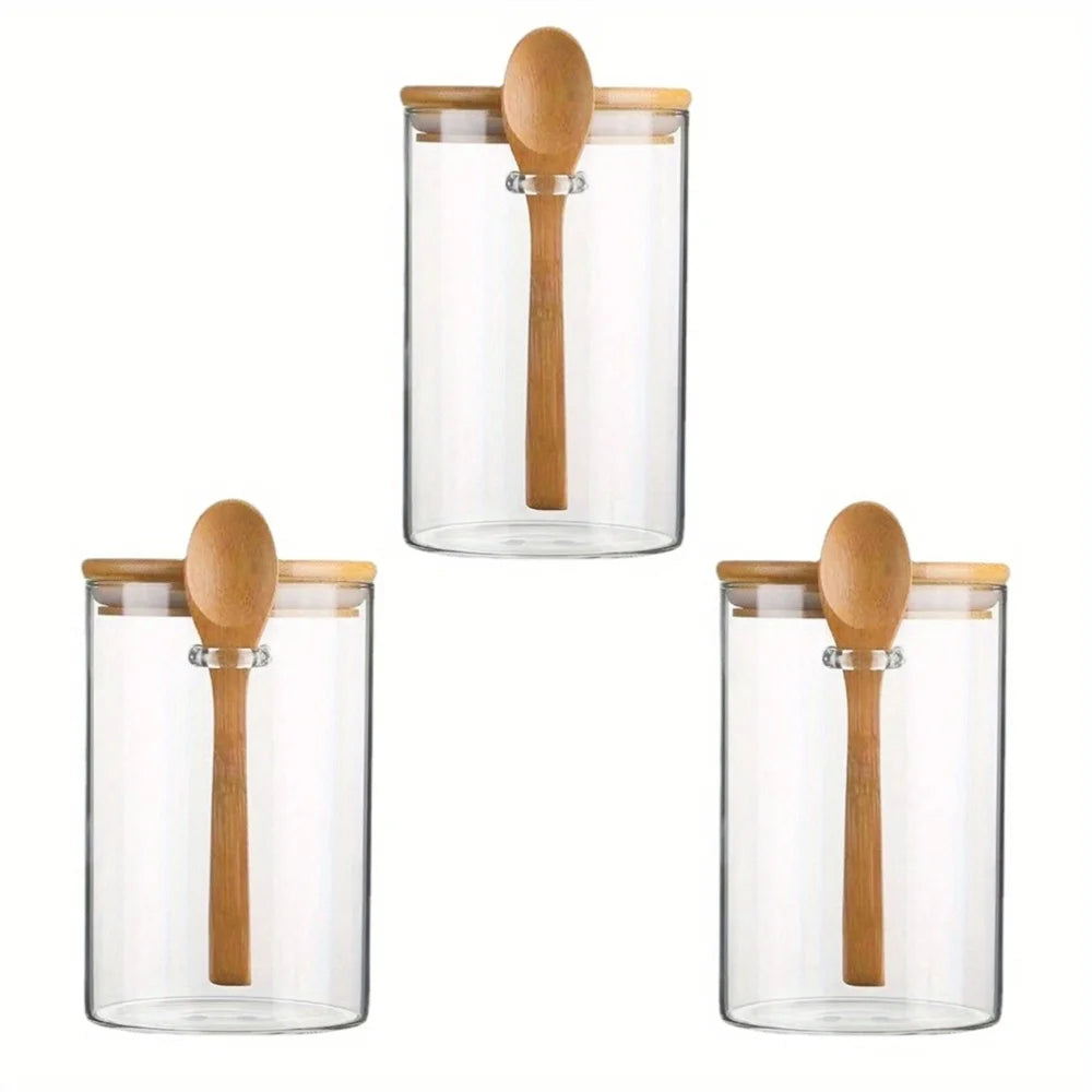 Three clear glass jars with wooden lids used for meal prep storage.