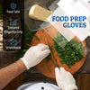 A hand wearing a white glove is using a knife to cut fresh green herbs on a wooden cutting board.
