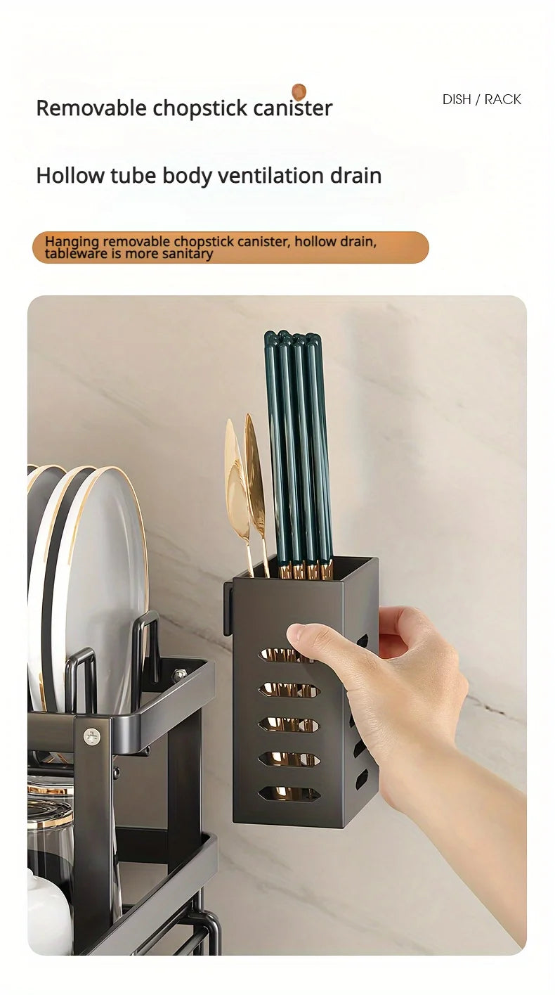 Une main tient un porte-serviettes en métal noir à barres verticales, avec un récipient pour baguettes amovible.