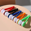 A set of colorful two-sided microfiber cleaning brushes for eyeglasses arranged diagonally on a light background.