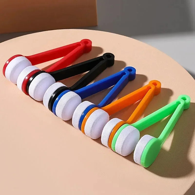 A set of colorful two-sided microfiber cleaning brushes for eyeglasses arranged diagonally on a light background.