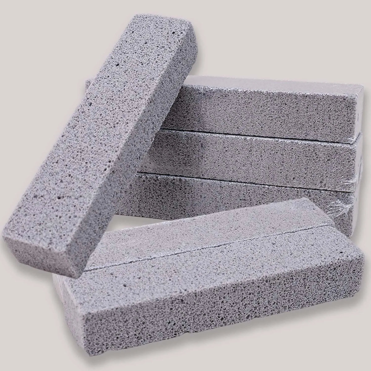 Pila de estropajos de piedra pómez natural gris en varias formas y tamaños rectangulares.