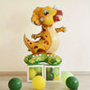 A yellow cartoon animal foil balloon shaped like a lion, resting on a green leaf base with several loose balloons.