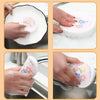 Hands are shown using natural cotton cleaning sponges to wash dishes in a kitchen sink.