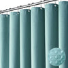 A set of vertical, ribbed shower curtains in a muted teal color hanging from a metal rod.