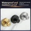 Three suction cup hooks in gold, black, and silver metal finishes displayed on a white marble surface.