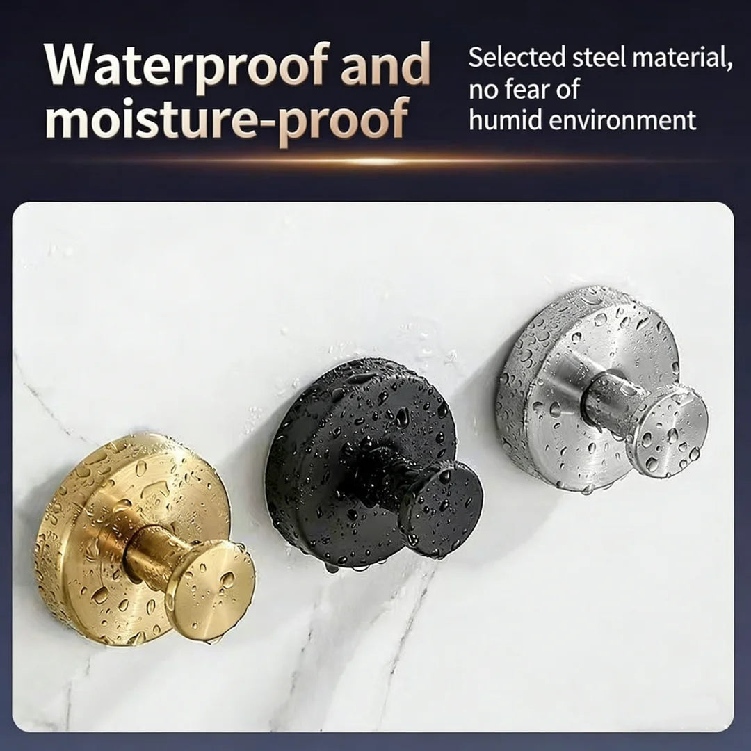 Three suction cup hooks in gold, black, and silver metal finishes displayed on a white marble surface.
