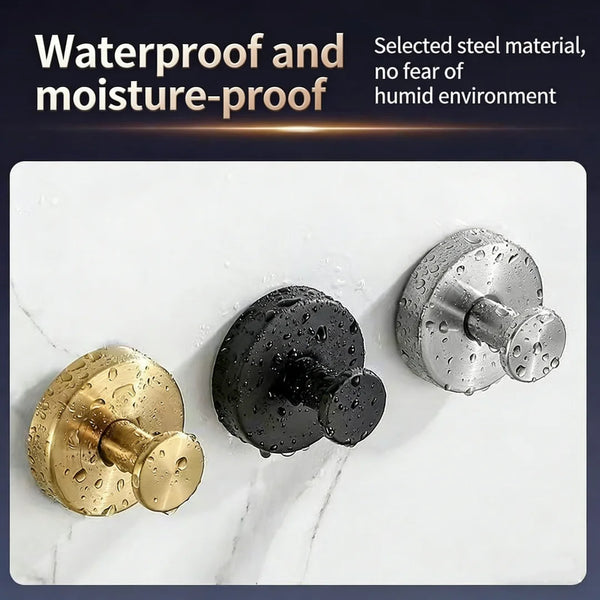 Three suction cup hooks in gold, black, and silver metal finishes displayed on a white marble surface.