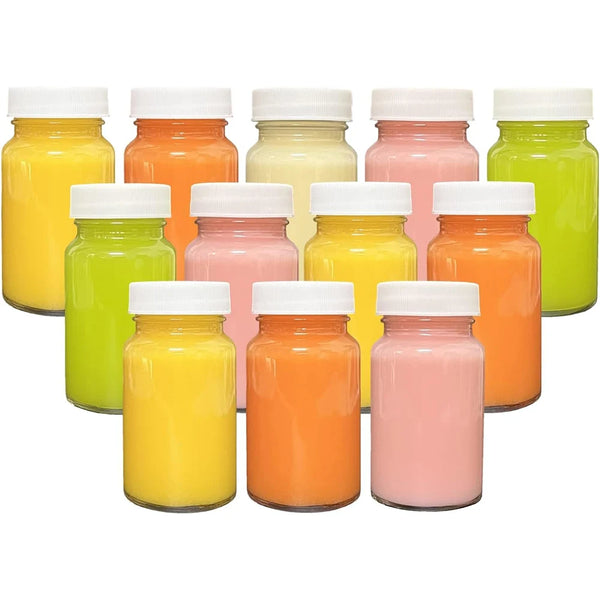 A collection of colorful glass juice bottles with white lids, featuring shades of yellow, orange, pink, and green.