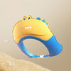 A yellow and blue adjustable baby bath shampoo shield cap is shown floating above a fluffy surface.
