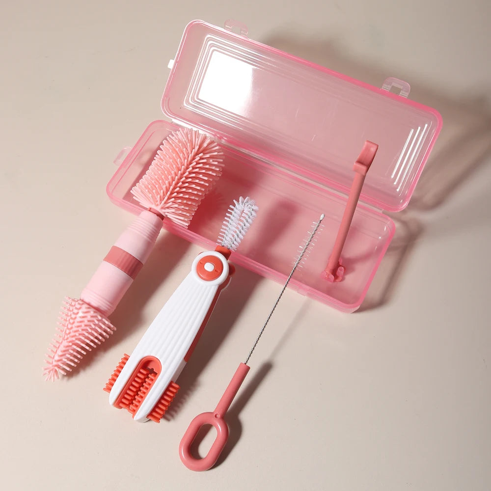 A pink silicone baby bottle cleaning set with a clear plastic case, including a brush and a cleaning tool.