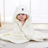Baby trägt ein weißes Kapuzenhandtuch- und Wickelset mit Bärengesicht-Design.