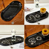A set of black marble silicone trays and silver chains used as a kitchen and bathroom organizer.