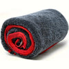 A rolled grey microfiber car drying towel with a red accent, showing its texture and compact form.