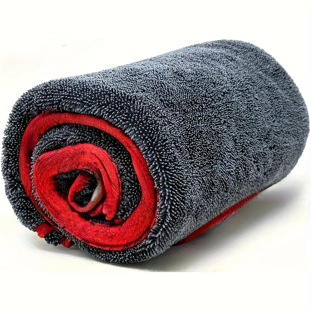 A rolled grey microfiber car drying towel with a red accent, showing its texture and compact form.