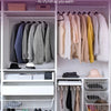 Elegant closet display featuring various garments and non-slip velvet hangers in a white shelving unit.