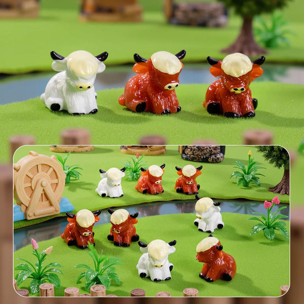 A set of resin figurine decor featuring Highland cow figures in white and orange colors on a green landscape.