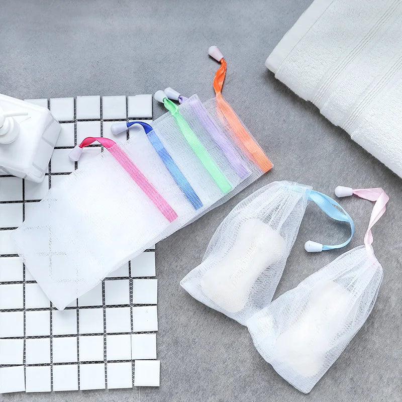 A collection of colorful exfoliating mesh soap pouches for body and face displayed on a gray surface.