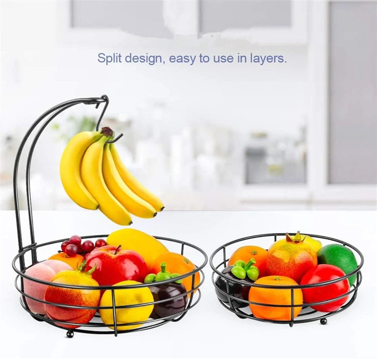 A black metal two-tier fruit basket organizer filled with various colorful fruits like apples, oranges, and bananas.