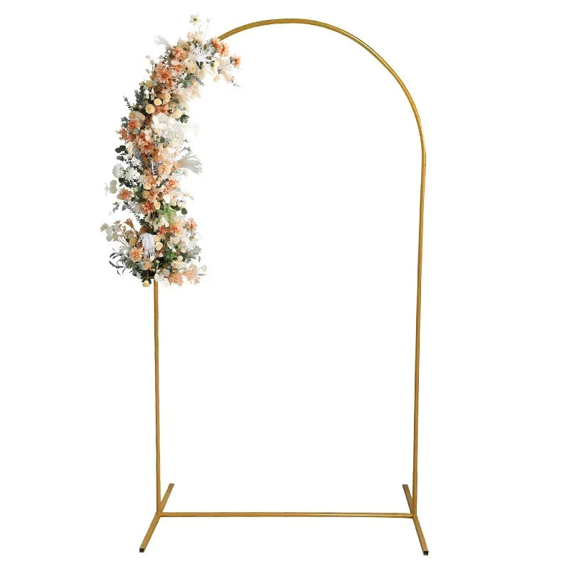 A gold arch stand decorated with white and peach floral arrangements for party or event decor.