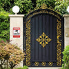 A black wooden gate with gold decorative scrollwork and a diamond pattern, set between two stone pillars.