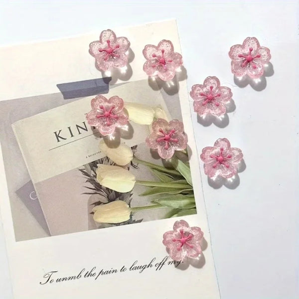 A set of pink cherry blossom fridge magnets featuring delicate floral designs and a handwritten quote.