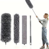 A woman is using a retractable microfiber dust duster, which features a fluffy head and a long handle.