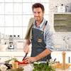 A man wearing an oil-proof canvas apron is preparing food in a bright kitchen setting.