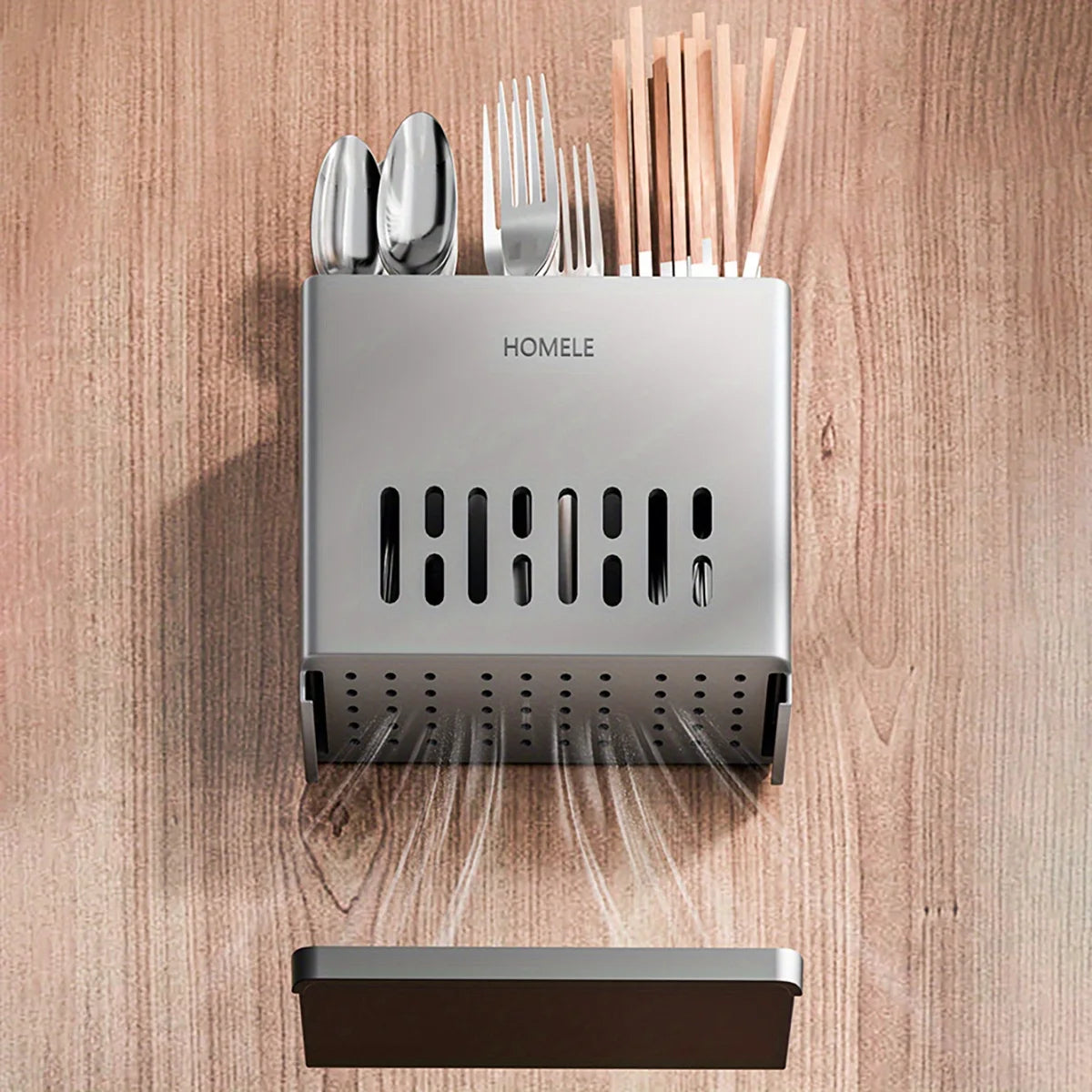 A silver cutlery storage rack with a drain base and a separate dark tray, set against a wooden background.