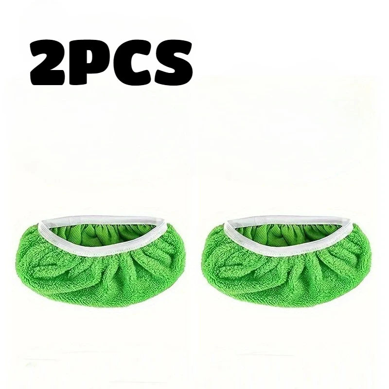 Two pieces of green reusable mop replacement cloths with white trim.
