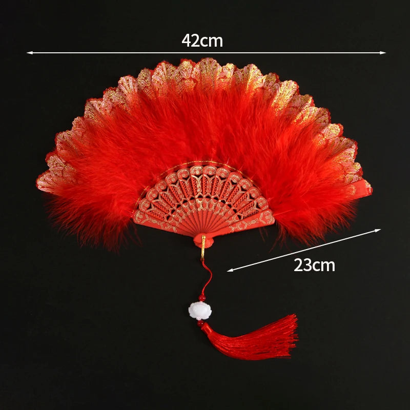 A vibrant red lace fabric folding hand fan with a decorative fringe and tassel.