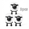 Three black and white decorative toilet paper holders shaped like cows.