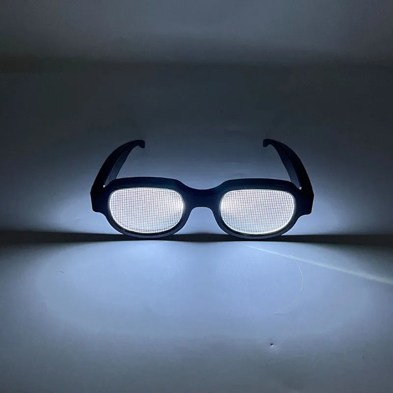 A pair of black LED light up anime glasses with a mesh lens illuminated against a dark background.