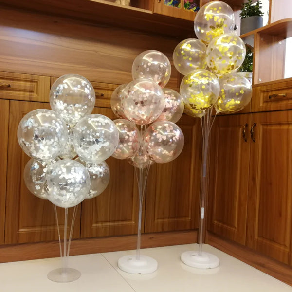 A display of clear and gold-tinted balloons on stands in a wooden cabinet setting.