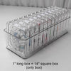 A clear plastic jewelry organizer box containing 14 square boxes and one long box.