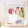 A wooden clothing rack displaying a multi-pack of non-slip velvet hangers for children.
