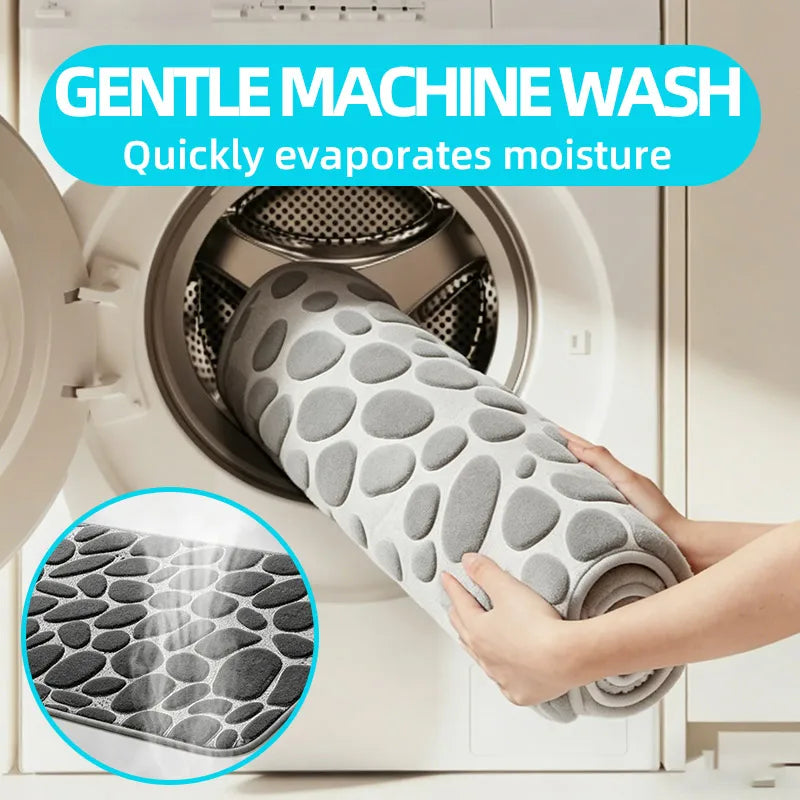 A hand holds a soft pebble embossed bathroom rug designed to quickly evaporate moisture for machine washing.