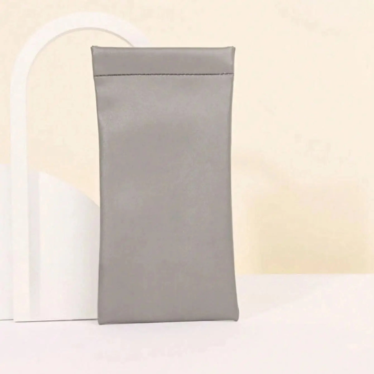 A rectangular gray PU leather squeeze eyeglasses case with a soft lining is shown against a light background.