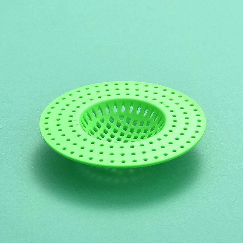 A bright lime green kitchen sink drain strainer and hair catcher with a perforated mesh design.