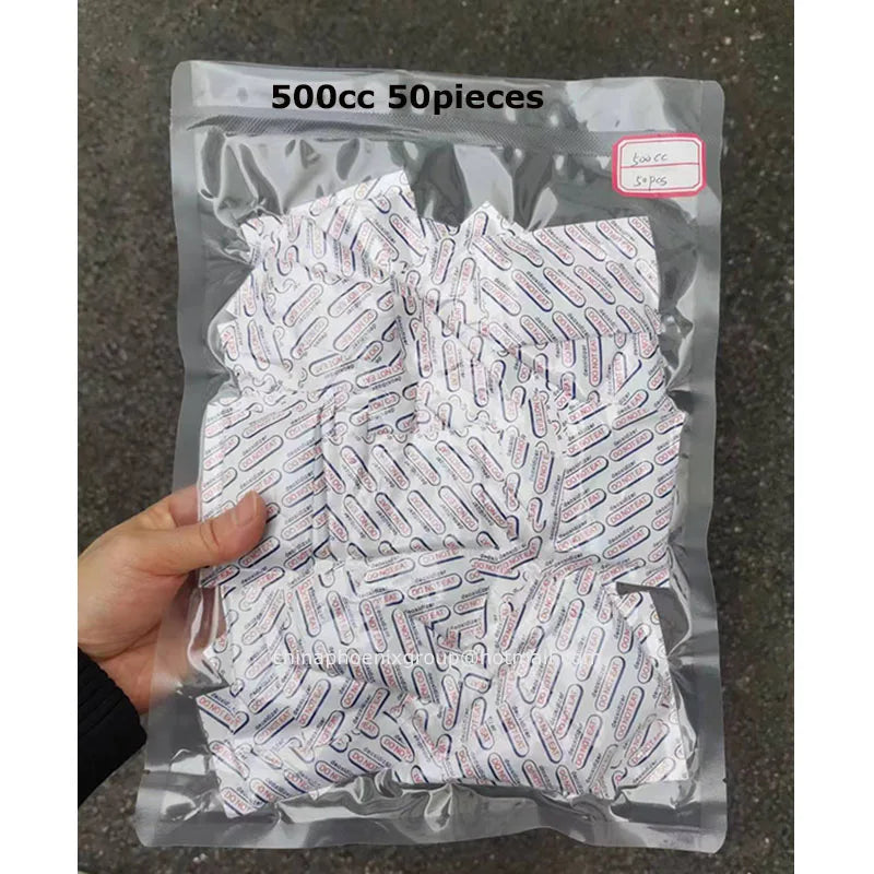 A hand holds a clear plastic bag containing 50 pieces of food-grade oxygen absorbers for extended dry food storage.