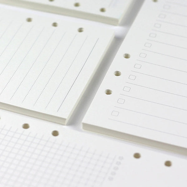 Close-up view of white loose leaf notebook refill paper with ruled lines and dotted guides.