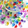 A close-up view of crushed, colorful crystal ice stones scattered on a white surface.