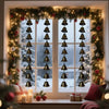 A vintage metal wind chime decoration hanging in a window decorated with festive greenery and lights.