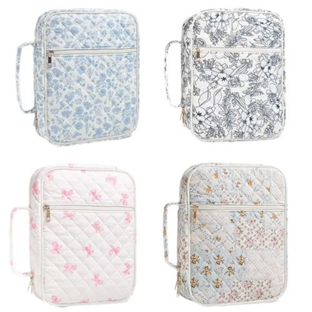 A collection of four floral quilted Bible cover bags in light blue, gray, pink, and white patterns.