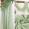 Light sage green sheer chiffon fabric draped vertically and folded into a swirl.