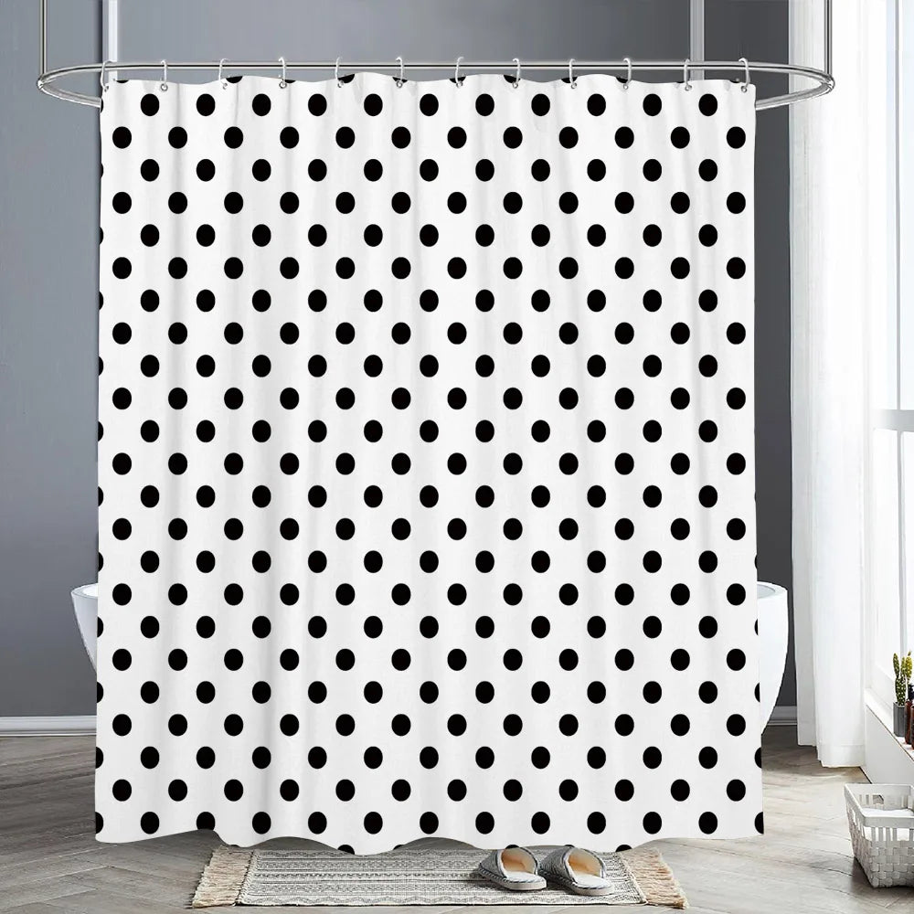 White shower curtain with a black polka dot pattern hanging on a metal rod.