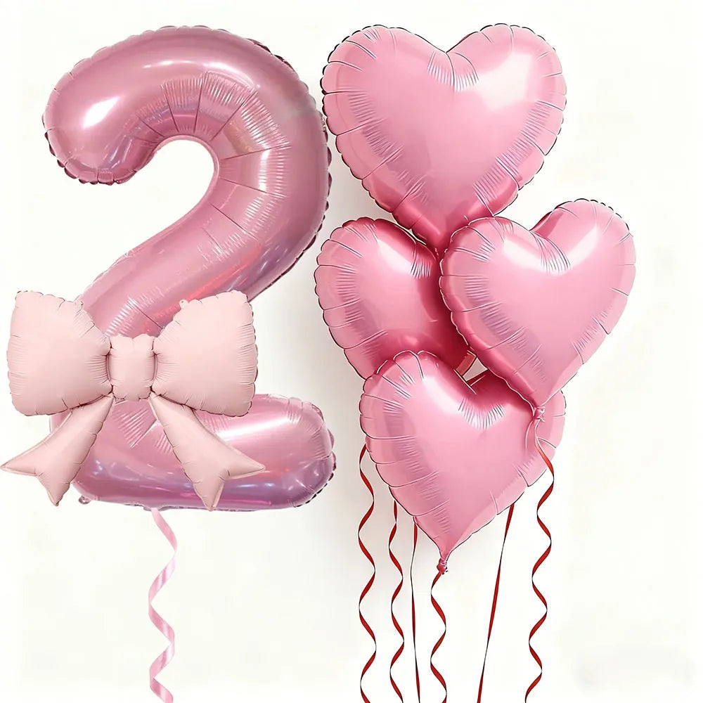Un juego de seis globos de látex en forma de corazón rosa, incluyendo el número dos y varios corazones con cintas.