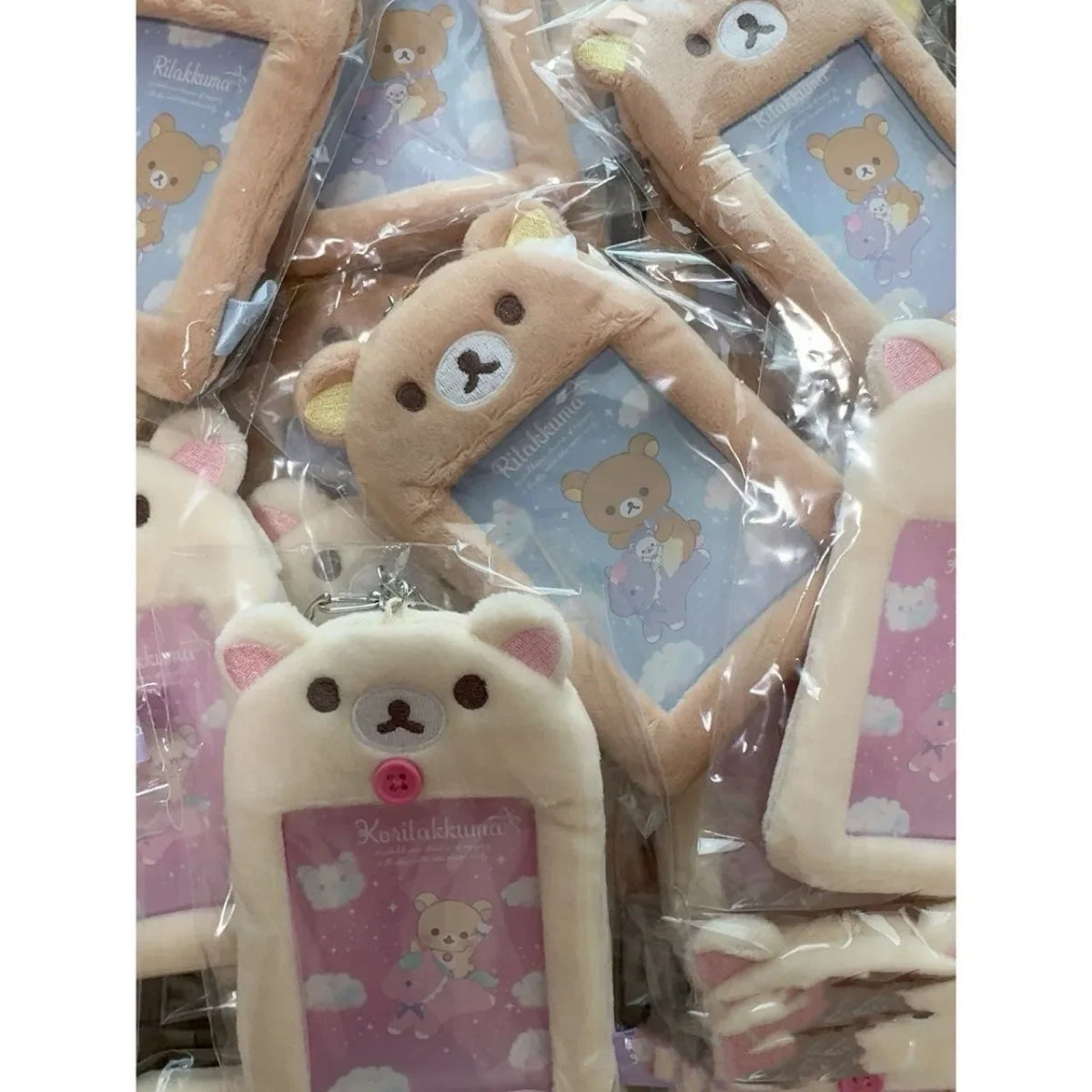 A collection of Rilakkuma plush ID card holders and keychains in various colors and designs.